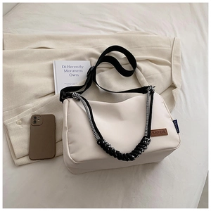 Détail du sac bandoulière en toile blanche avec sangle noire et cordelette tressée