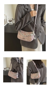 Détail du sac sous l'aisselle en tweed rose avec chaîne argentée et nœud décoratif