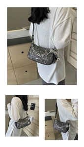 Détails du sac à bandoulière tissé gris avec chaîne argentée et breloque papillon