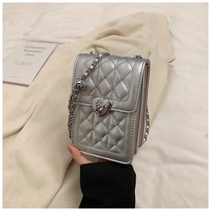 Detail of silver quilted phone bag featuring a heart-shaped metal lock and chain strap