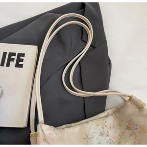 Close-up of vintage floral jacquard fabric and delicate cream shoulder straps on tote bag