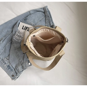 Interior view of beige canvas tote bag with zipper pocket and multi-compartment lining