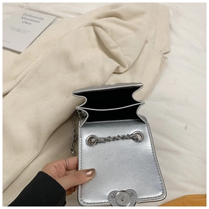 Detail of silver quilted mini bag with double compartments and metal chain strap