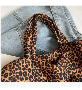 Dettaglio della borsa tote in tela leopardata con manici rinforzati e cuciture robuste