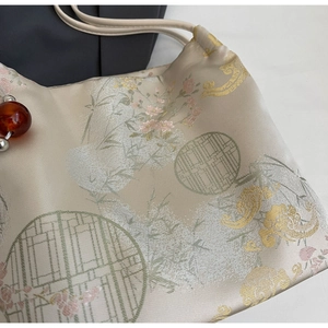 Close-up of traditional Chinese silk tote bag with floral embroidery and bamboo pattern