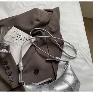 Détail du sac croissant argenté en similicuir avec plis et bandoulière à nœud chic