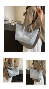 Vue détaillée du sac cabas tissé bleu clair montrant la texture et les anses en cuir