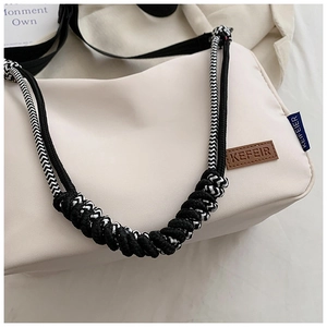 Détail d'un sac en toile crème avec bandoulière en corde tressée et patch en cuir