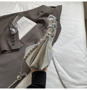 Détail du sac à main plissé argenté avec breloque perle et bandoulière en chaîne