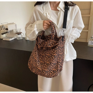 Dettaglio della borsa tote in tela leopardata con tracolla nera regolabile al caffè