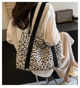 Detalle del bolso tote de lona con estampado de leopardo, bolsillo lateral y correas negras