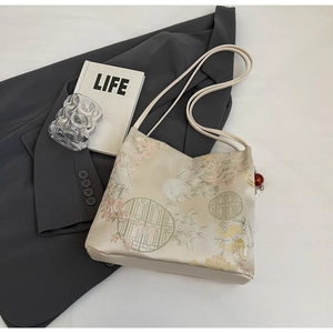 Detail of cream satin tote bag featuring traditional Chinese floral embroidery and beads