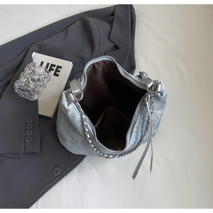 Detailed view of the light blue denim tote bag interior with chain strap and lining
