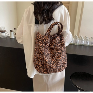 Dettaglio della borsa tote leopardata in tela con tracolla nera ampia e regolabile