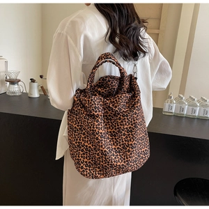 Dettaglio della borsa tote in tela leopardata con ganci metallici e doppi manici