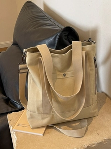 Large khaki canvas tote bag with adjustable strap and front snap pocket for daily use
