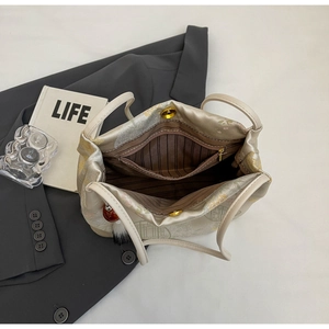 Detailed interior of tote bag with brown striped lining, zip pocket and magnetic closure