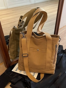 Minimalist large canvas tote bag with adjustable shoulder strap and multiple pockets