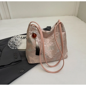 Close-up of pink satin jacquard tote bag with traditional Chinese embroidery and tassel detail