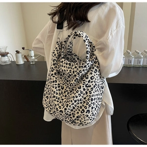 Vista posteriore di una borsa tote in tela leopardata portata a tracolla in un bar