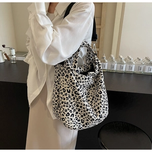 Dettaglio della capiente borsa tote in tela leopardata con tracolla nera regolabile