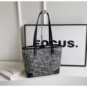 Détail du grand sac cabas à carreaux gris et noir avec anses en cuir et plaque en métal