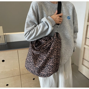 Dettaglio della borsa tote in tela leopardata con tracolla larga e fibbia argentata