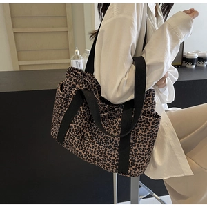 Detalle del bolso tote de lona con estampado de leopardo y correas de nailon negras