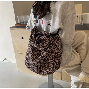 Vista posteriore di una modella con una borsa tote grande in tela con stampa leopardata