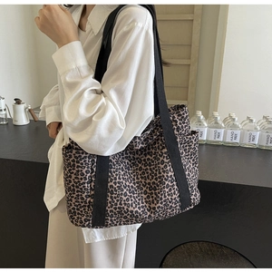 Detalle de un bolso tote de lona con estampado de leopardo y bolsillos laterales