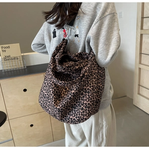 Vista dettagliata della borsa tote in tela leopardata con tracolla nera regolabile sulla spalla