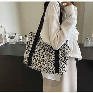 Detalle macro del bolso tote de lona con estampado de leopardo y bolsillo lateral abierto