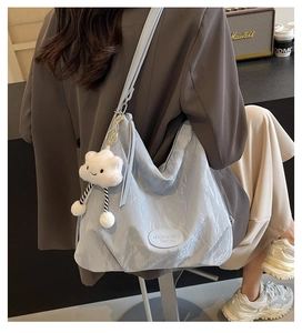 Sac fourre-tout bleu clair texturé avec pendentif nuage blanc porté par un modèle