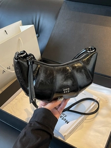 Sac croissant chic en cuir verni noir avec design plissé et logo argenté élégant