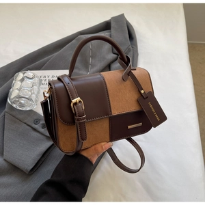 Dettaglio borsa in pelle bicolore con trame lisce e opache e finiture in metallo dorato