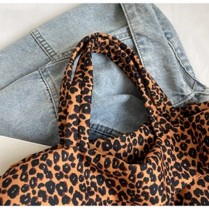 Dettaglio della borsa tote in tela leopardata su denim per un look casual alla moda