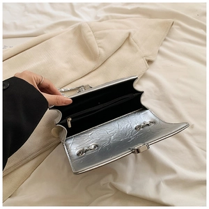 Silver wrinkled texture crossbody bag showing black inner lining and zipper pocket