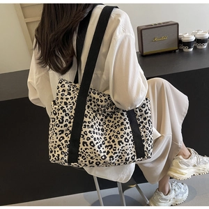 Detalle del bolso tote de lona de leopardo con bolsillos laterales y asas negras