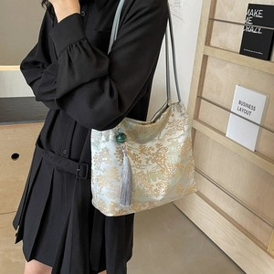 Chinese style embroidered tote bag with landscape pattern and tassel detail on shoulder