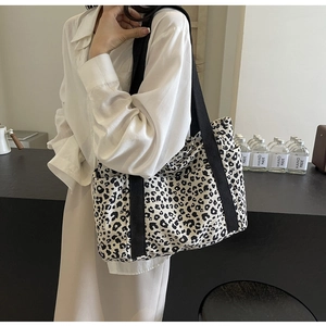 Detalle de bolso tote de lona con estampado de leopardo, bolsillo lateral y gran capacidad