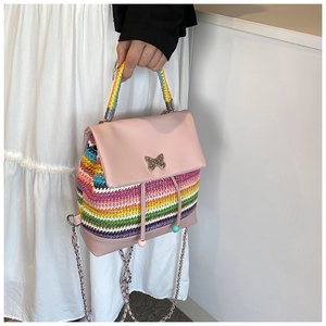 Détail d'un mini sac à dos tissé arc-en-ciel avec boucle métallique papillon