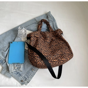 Borsa tote in tela leopardata con tracolla regolabile e oggetti di scena lifestyle