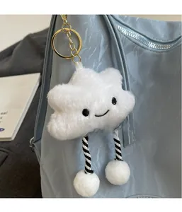 Gros plan d'un charme nuage en peluche blanche avec visage souriant sur un sac