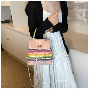 Mini sac à dos arc-en-ciel tressé avec papillon métallique porté par le mannequin