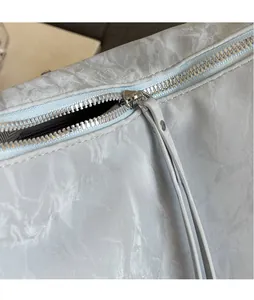 Détail du sac en cuir texturé bleu clair avec fermeture éclair en métal argenté lisse