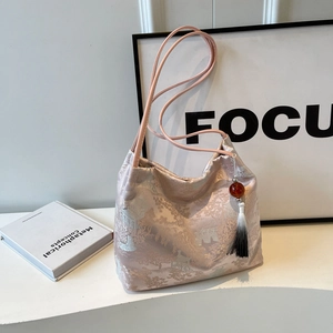 Pink satin tote bag with traditional silver embroidery and decorative tassel detail