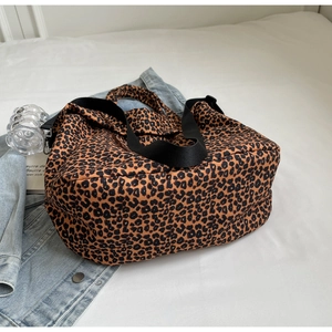 Dettaglio della borsa leopardata con tracolla in nylon nero e fibbie in metallo robuste