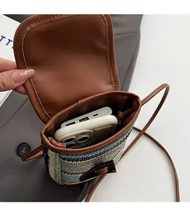 Detail view showing internal storage for a large smartphone and power bank in straw bag