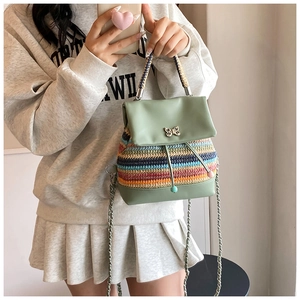 Détail d'un sac à dos tissé à rayures colorées avec fermoir papillon et bandoulière chaîne