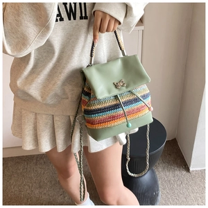 Détail du sac à dos tissé bicolore avec rabat en cuir et boucle papillon métallique
